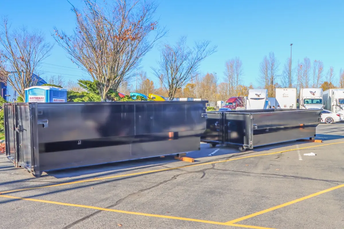 Professional dumpster rental service with roll-off container on residential driveway in Island Park